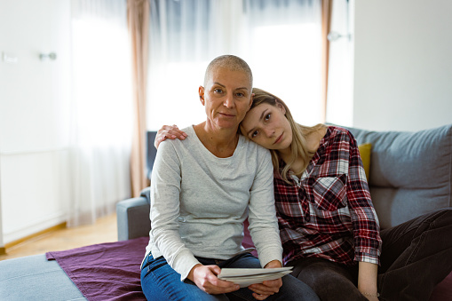 Woman with cancer and her daughter browsing family photos