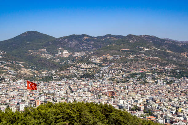 The waving flag of Turkey. The waving flag of Turkey. Against the background of the city of Alanya and the mountains. türkiye country stock pictures, royalty-free photos & images