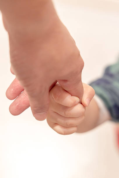 istock The boy's hand was held onto his father's finger while walking to stabilize him. 1396909658