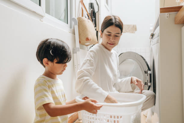istock Housewife carry baby while using washing machine 1396911242