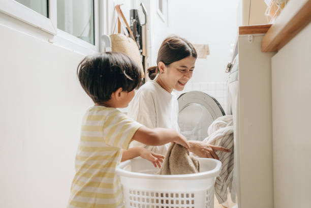 istock Housewife carry baby while using washing machine 1396911263