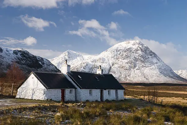 Blackrock Cottage near Glencoe, Scotland, with snow on the mountains