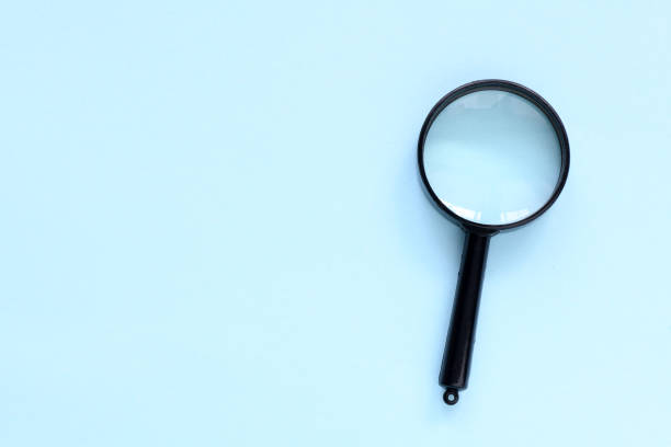 istock Black magnifier on a blue background. 1396913624