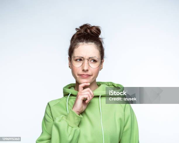 Confused Woman With Brown Hair Bun Stock Photo - Download Image Now - Looking At Camera, Uncertainty, Young Women