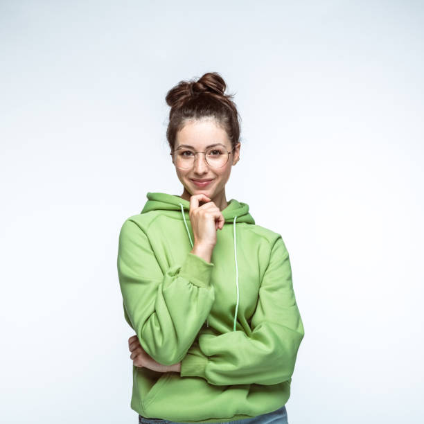 istock Smiling woman standing with hand on chin 1396916356