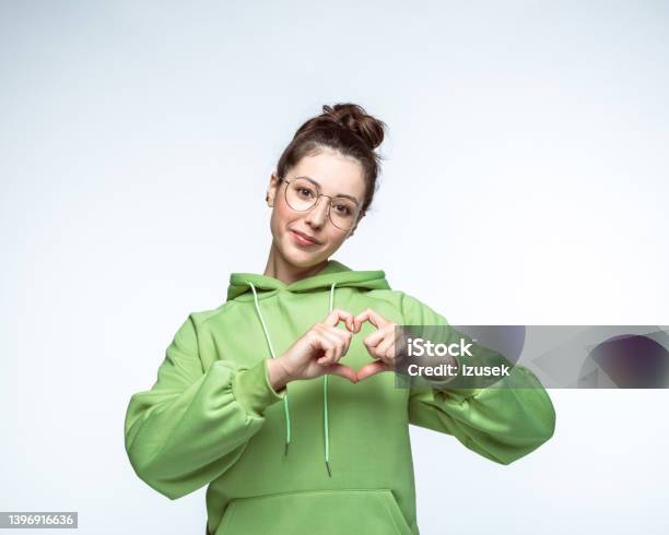 Woman Gesturing Heart Shape Over White Background Stock Photo - Download Image Now - Heart Shape, Young Women, Hand Sign