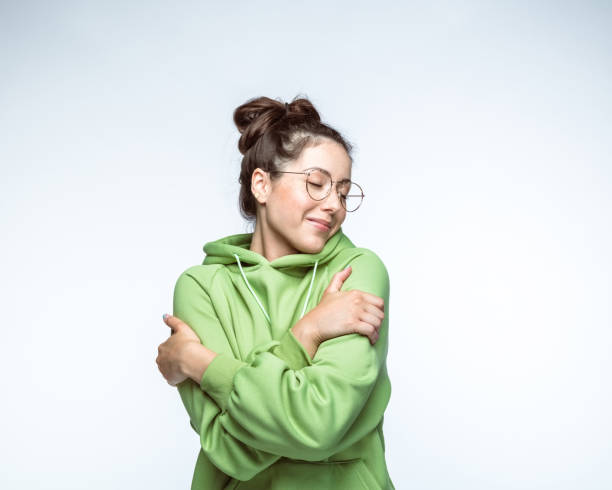 istock Woman with eyes closed hugging self 1396917074