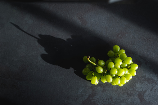 Fresh green grape on the table with light reflection and shadows