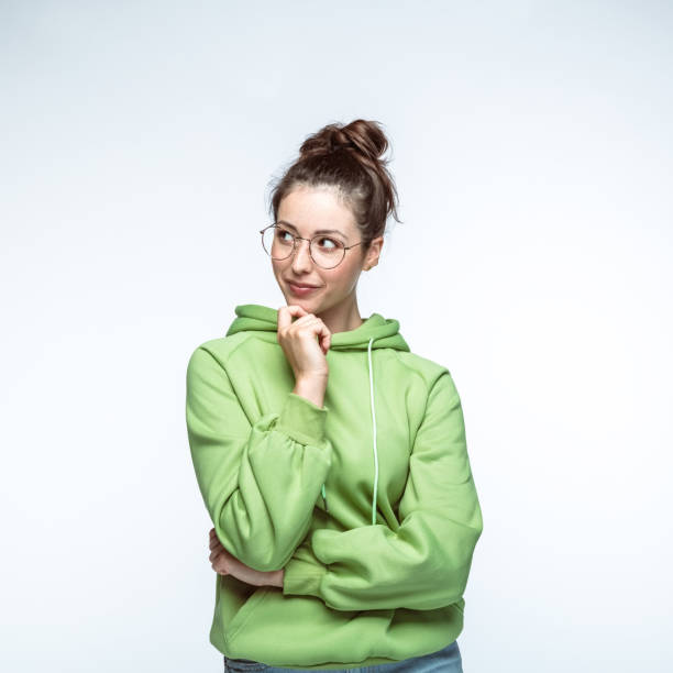 istock Young woman standing with hand on chin 1396917844