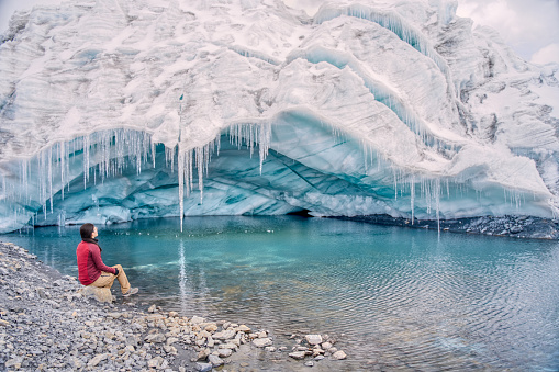 Tourist woman seated looking at Pastoruri glacier cave