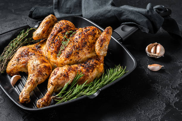 istock BBQ spatchcocked barbecue whole chicken on grill pan. Black background. Top view 1396918233