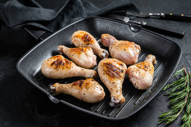 istock Grilled Chicken leg drumstick with herbs, poultry meat. Black background. Top view 1396919059