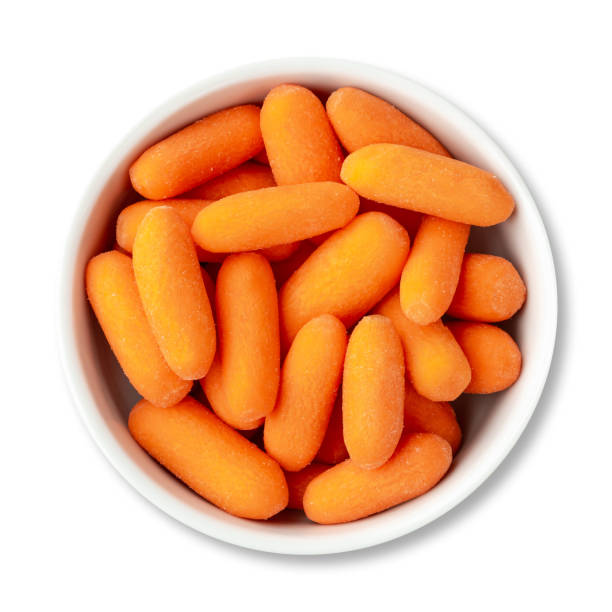 baby carrots in a bowl isolated over white background - carrot isolated white carotene imagens e fotografias de stock