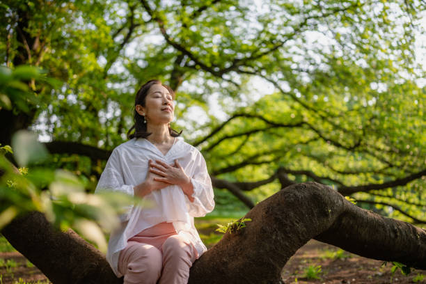 Woman meditating in nature stock photo