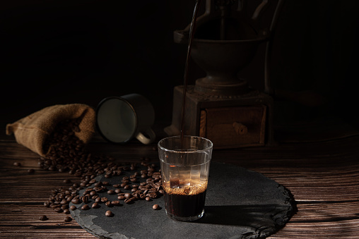 Café, taza con café y granos de café sobre una piedra gris sobre madera, foto estilo comida oscura, enfoque selectivo. photo