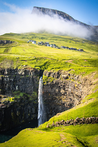 waterfall in Gasadalur in Faroe Islands, mountains, fog
