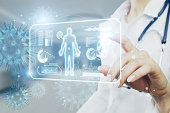 Close up of woman doctor hand pointing at abstract glowing medical cardiology interface on blurry hospital background with virus. Hi-tech technology and medicine of the future concept. Double exposure.