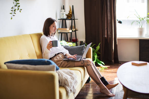 istock Young woman amputee with prosthesis working on laptop at home 1396920713