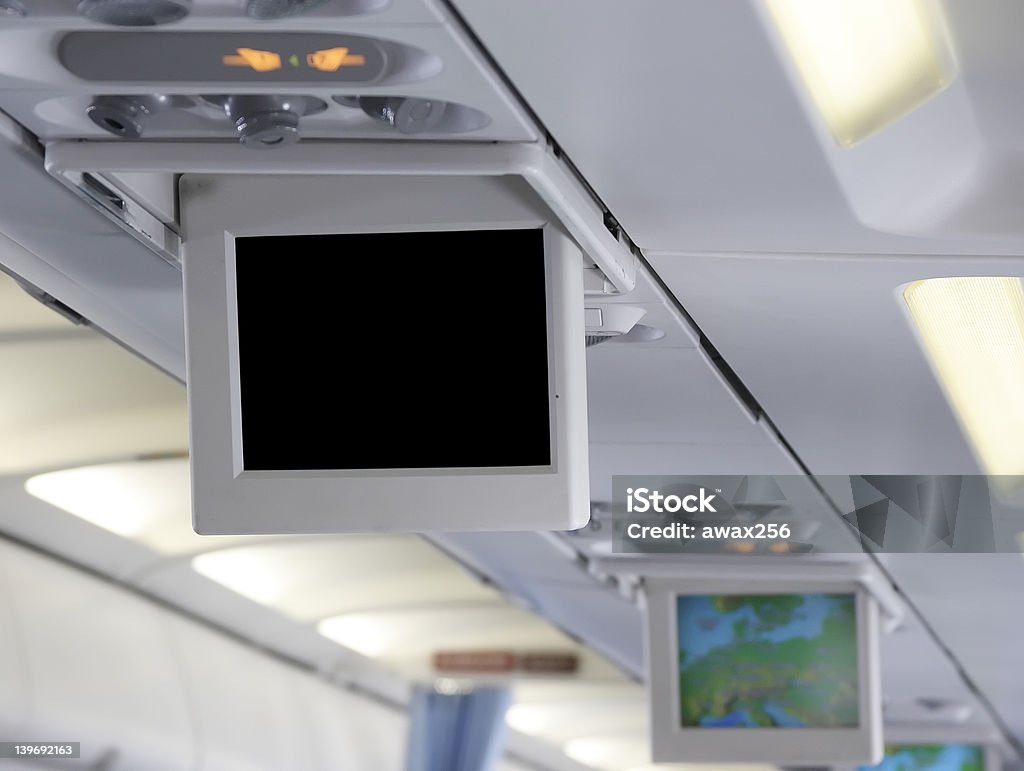 Airplane cabin interior with a blank video screen Vertical shot of airplane interior with a blank video screen. You can put whatever you want on it Airplane Stock Photo