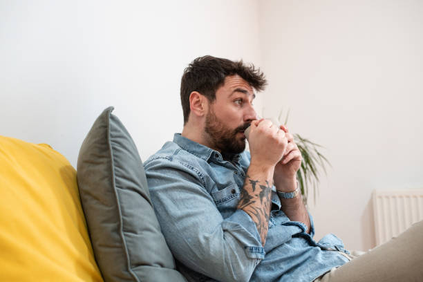 istock Handsome young man drinking tea at home 1396921665