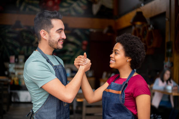 istock Team of waiters working at a restaurant and shaking hands 1396921744