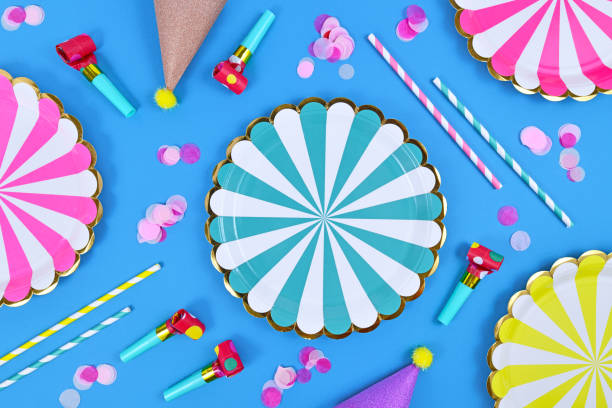 istock Party flat lay with paper plates, drinking straws and confetti on blue background 1396922000