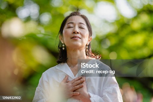 istock Woman meditating in nature 1396922902