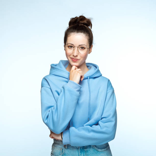 istock Young woman standing with hand on chin 1396924603
