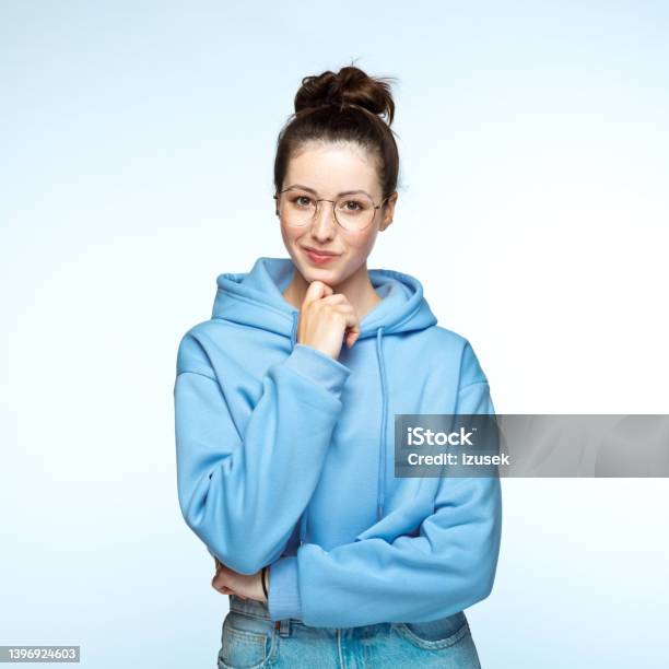 Young Woman Standing With Hand On Chin Stock Photo - Download Image Now - Formal Portrait, White Background, 20-24 Years