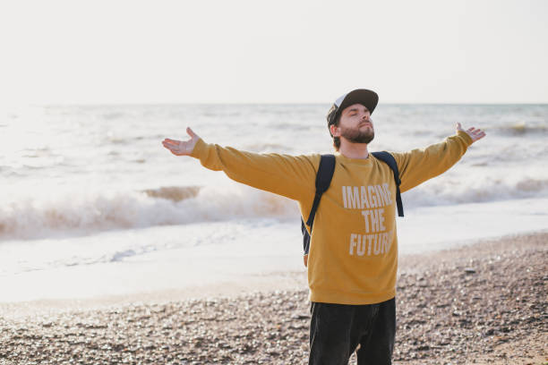 istock Young man traveler exploring empty beach near ocean or sea. 1396925827