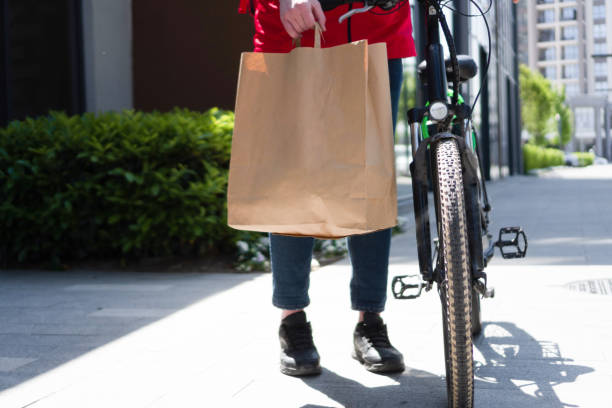 istock Delivery man with bicycle and paper bag 1396926707