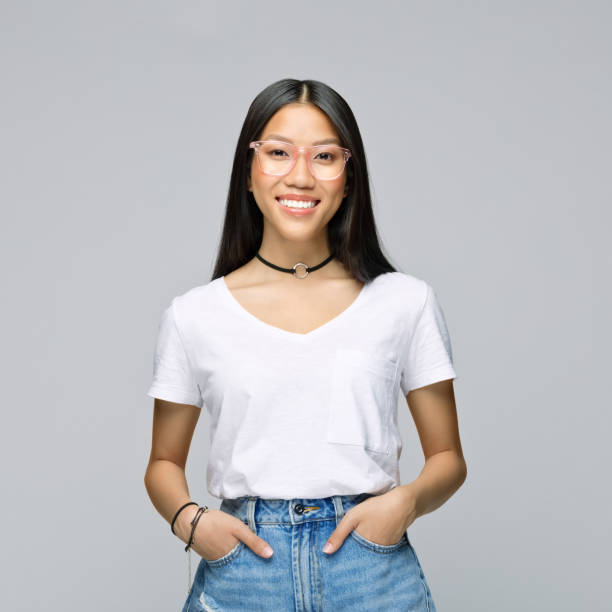 Smiling woman standing with hands in pockets