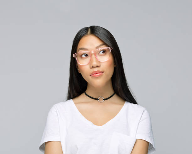 istock Thoughtful young woman against gray background 1396929650