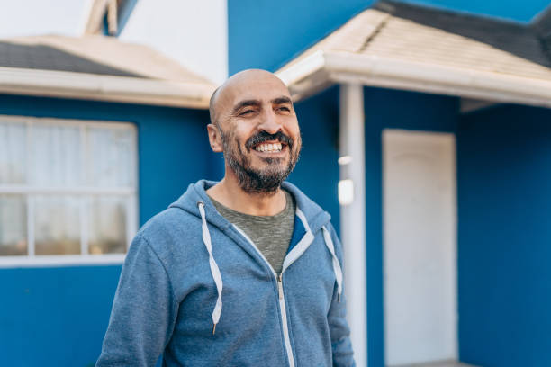 happy man in front of his new house - candid imagens e fotografias de stock