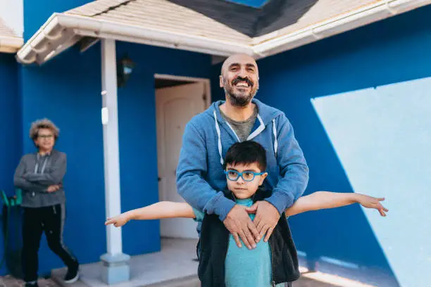 Photo of Father and son in front of new house