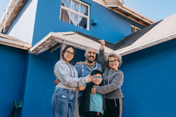 Family in front of new house A day in the life of a Chilean family living in a residential neighborhood in the capital Santiago. happy family with key of their new house stock pictures, royalty-free photos & images
