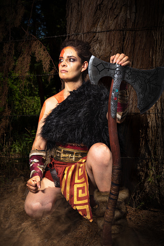 COSPLAY SESSION. PORTRAIT OF A WARRIOR. AXE. VERTICAL PHOTOGRAPHY. COLOR.