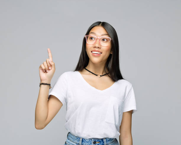 istock Woman pointing against gray background 1396929889