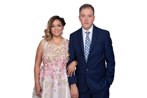 A bride and groom posing very serious on a white background.