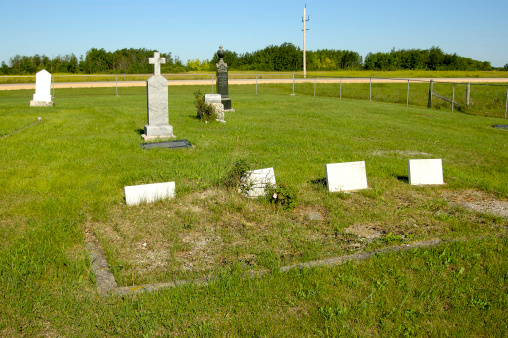 a small graveyard with blank white markers in the foreground