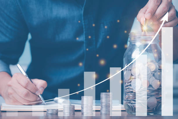 istock Man's hand estate collecting money with coins , display graphs as a component, saving ideas, business, building stability in life. 1396940542