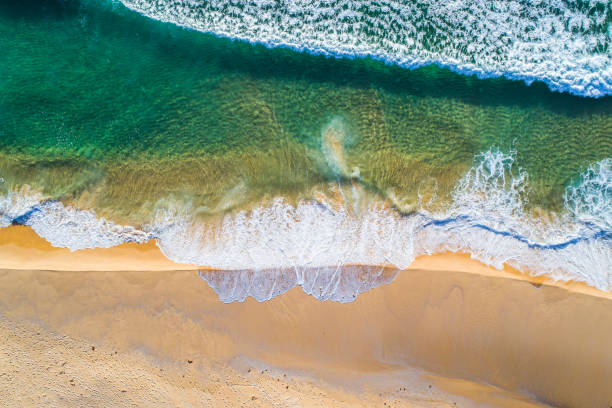 istock Clear teal blue ocean waves rolling onto shore 1396944596