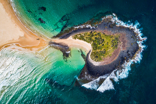 An aerial view of a beautiful beach and island on a bright sunny day in Ireland