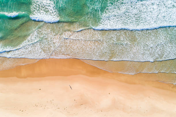 istock Full frame view of directly above rolling ocean waves along golden sandy coast 1396944642