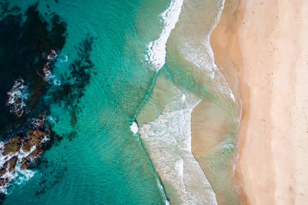 istock Pattern of waves rolling onto sandy beach coastline 1396944671