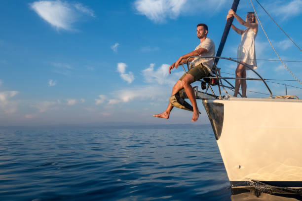istock Young couple on yacht bow in sunset time 1396946036