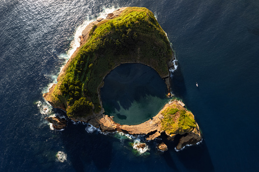 Aerial top view of majestic Sao Miguel island with round lagoon located in middle of blue sea in Azores