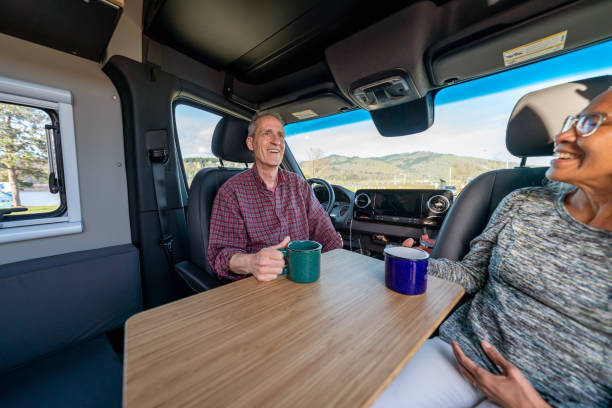 istock Adventurous senior couple enjoying hot chocolate while on camping trip 1396946276