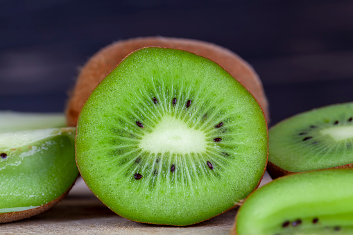 sliced kiwi fruit of green color, kiwi fruit cut it into thin slices during dessert cooking