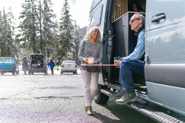 pareja de ancianos aventureros disfrutando de vacaciones de invierno en su autocaravana - skiing snow couple mountain fotografías e imágenes de stock